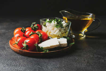 Plate with tasty feta cheese and tomatoes on dark backgroundの写真素材