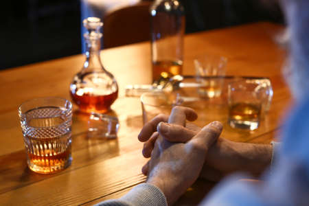 Senior man with glass of drink late in the evening at home, closeupの写真素材