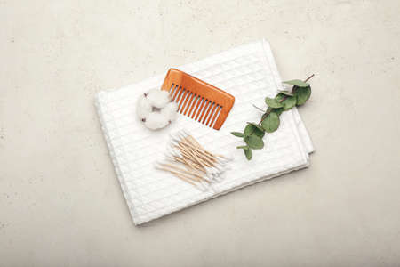 Cotton swabs, flower and comb on light background