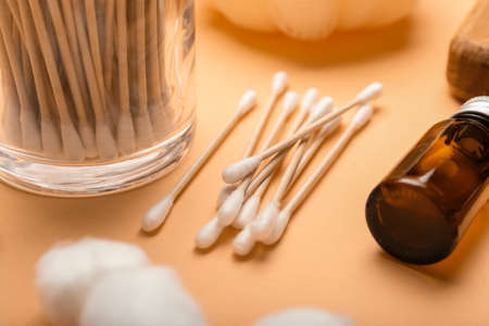 Cotton swabs, balls and cosmetic product on color background, closeupの写真素材