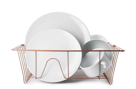 Set of clean dishes in drainer on white backgroundの写真素材