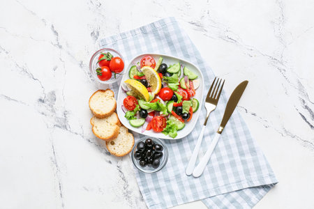 Composition with tasty Greek salad and bread on light backgroundの写真素材