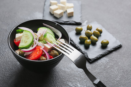 Bowl with tasty Greek salad on dark background, closeupの写真素材