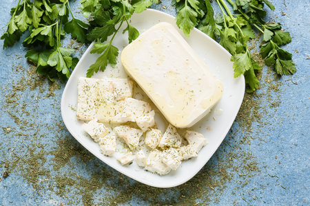 Plate with tasty feta cheese and parsley on color backgroundの写真素材
