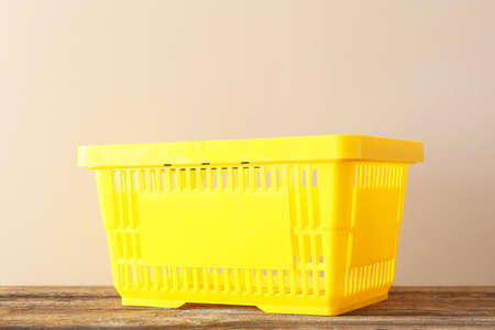 Shopping basket on table against light background
