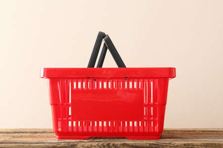 Shopping basket on table against light background