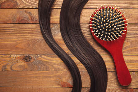 Hair brush with strands on wooden backgroundの写真素材