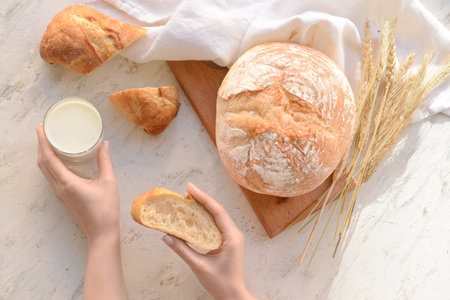 Female hands with slice of bread on grunge background