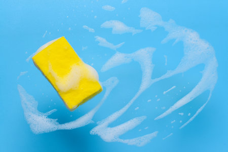 Cleaning sponge with foam on color backgroundの写真素材