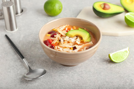 Bowl of tasty chicken enchilada soup on gray backgroundの写真素材