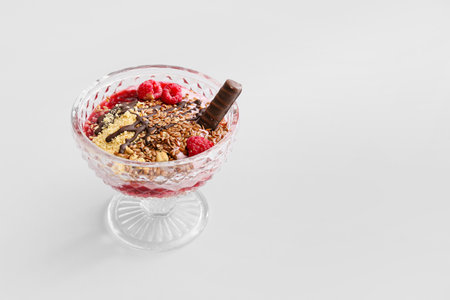 Tasty dessert with flax seeds and yoghurt in glass on light backgroundの写真素材
