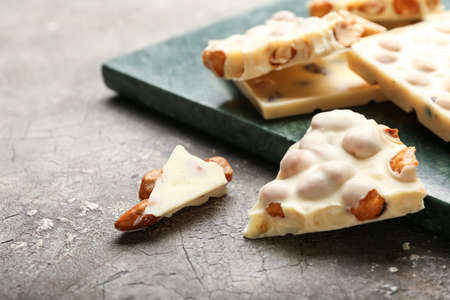Pieces of white chocolate with nuts on grunge backgroundの写真素材