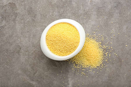 Bowl with raw couscous on grunge backgroundの写真素材