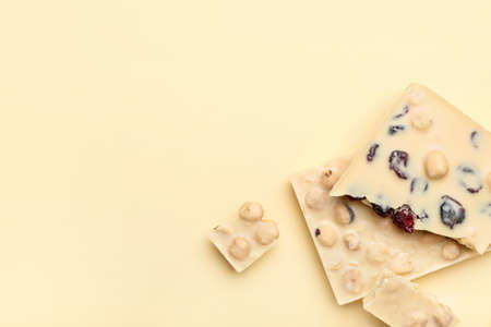 Pieces of tasty white chocolate on color backgroundの写真素材
