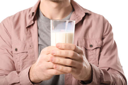 Young man with glass of milk on white background, closeupの写真素材