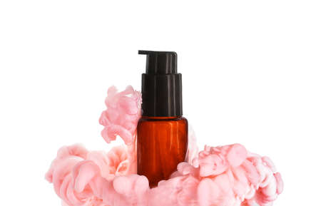 Bottle of cosmetic product in color smoke on white backgroundの写真素材