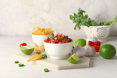 Bowl of tasty Pico de Gallo salsa and nachos on table