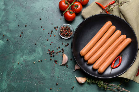Composition with tasty sausages and vegetables on color backgroundの写真素材