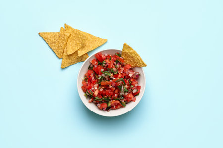 Bowl of tasty Pico de Gallo salsa and nachos on color backgroundの写真素材