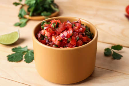 Bowl of tasty Pico de Gallo salsa on table