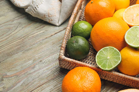 Basket with fresh citrus fruits on wooden backgroundの写真素材