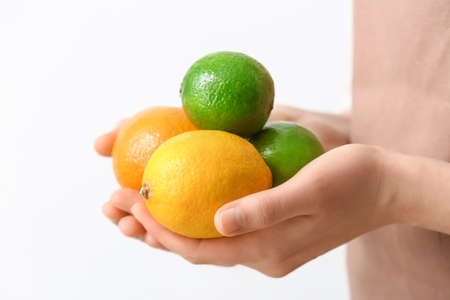 Woman with citrus fruits on light backgroundの写真素材