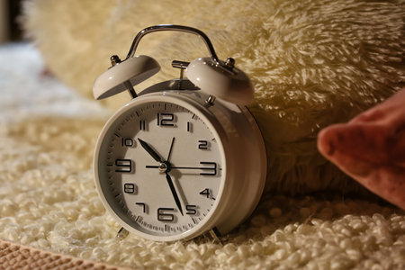 Alarm clock on bed at night, closeup