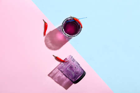 Glass of tasty cocktail with chili pepper on color backgroundの写真素材