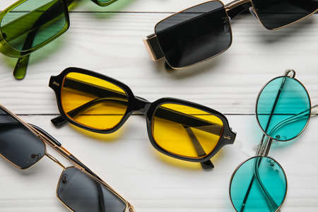 Different modern sunglasses on light wooden background, closeupの写真素材