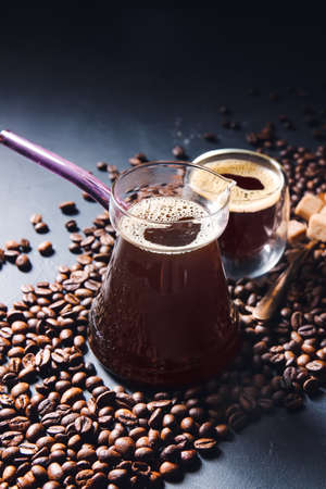 Pot and cup of hot turkish coffee with beans on dark backgroundの写真素材