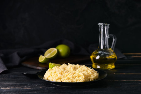 Plate with tasty couscous on dark wooden background