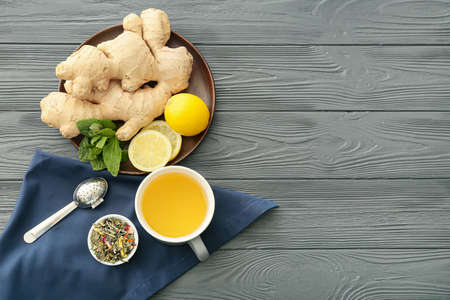 Cup of tea with ginger, mint and lemons on dark wooden backgroundの写真素材