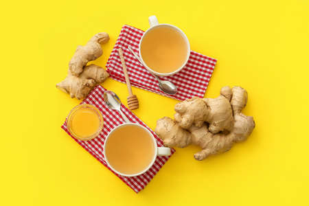 Cups of tea with ginger and honey on color backgroundの写真素材