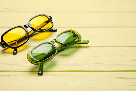 Different modern sunglasses on color wooden backgroundの写真素材