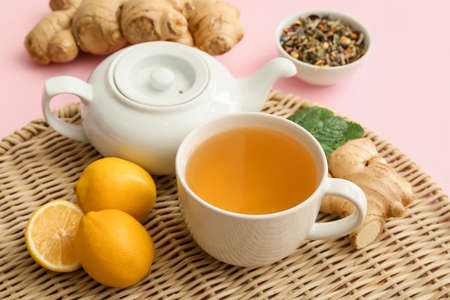 Teapot and cup of hot tea with ginger on color backgroundの写真素材