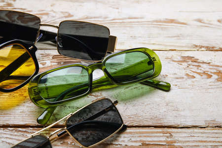 Different modern sunglasses on light wooden background, closeupの写真素材