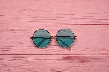 Stylish sunglasses on color wooden backgroundの写真素材
