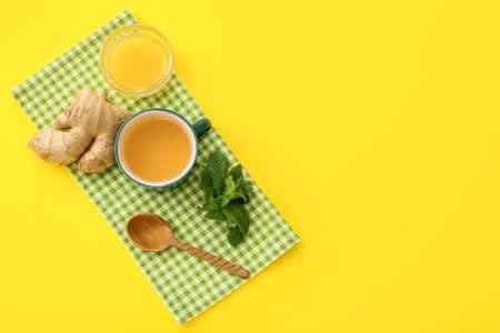 Cup of tea with ginger, mint and honey on color backgroundの写真素材