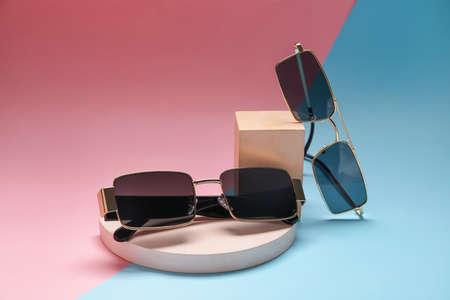 Different modern sunglasses on colorful background