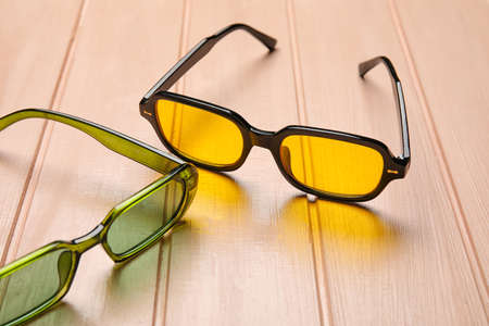 Different modern sunglasses on color wooden background, closeupの写真素材