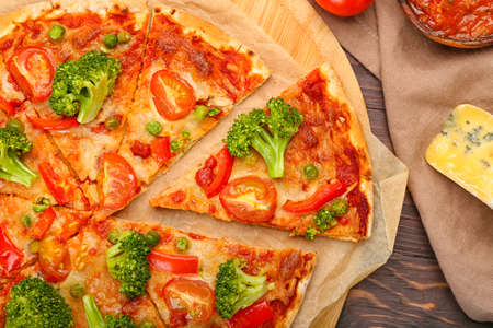 Board with tasty vegetarian pizza on wooden backgroundの写真素材