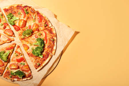 Board with tasty vegetarian pizza on color backgroundの写真素材