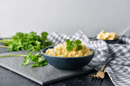 Bowl with tasty couscous and cilantro on tableの写真素材