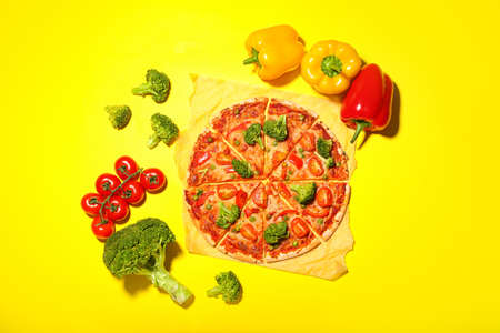 Parchment with tasty vegetarian pizza on color backgroundの写真素材