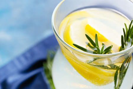 Glass of tasty lemonade with rosemary on color background, closeupの写真素材