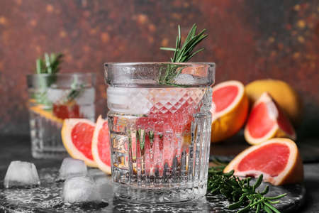Glass of tasty grapefruit cocktail with rosemary on dark background, closeupの写真素材