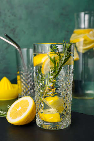 Glass of tasty lemonade with rosemary on color backgroundの写真素材