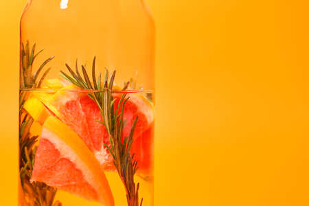 Jug of tasty grapefruit lemonade with rosemary on color background, closeupの写真素材