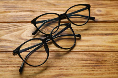 Different stylish eyeglasses on wooden background, closeupの写真素材