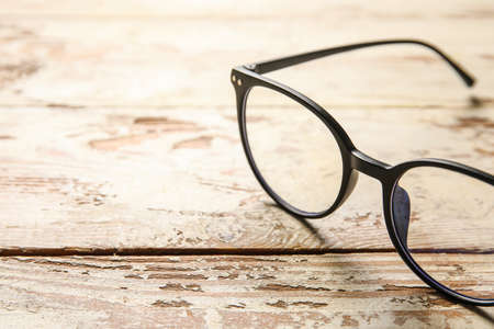 Stylish eyeglasses on light wooden background, closeupの写真素材